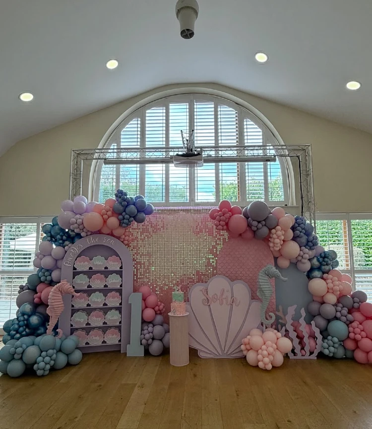 Iridescent Pastel Shimmer and Shell Favor Wall for a Coastal Luck Theme