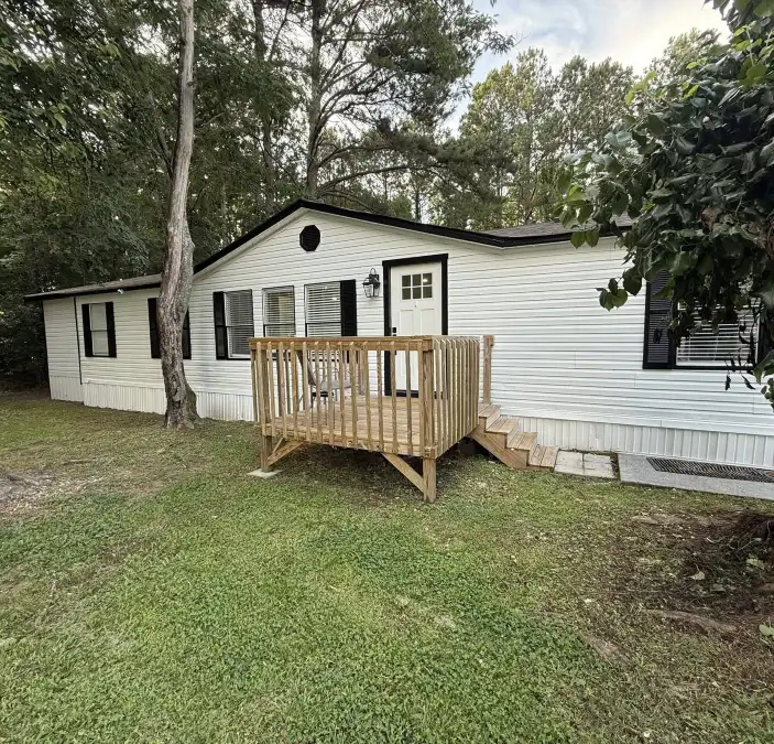 White Mobile Home with a Simple Wood Porch